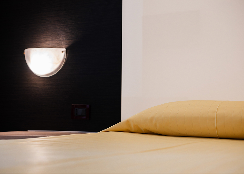 testata letto singolo con luce camera singola hotel bologna